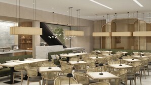 Un café moderno con varias mesas y sillas, una escalera y una zona de bar.