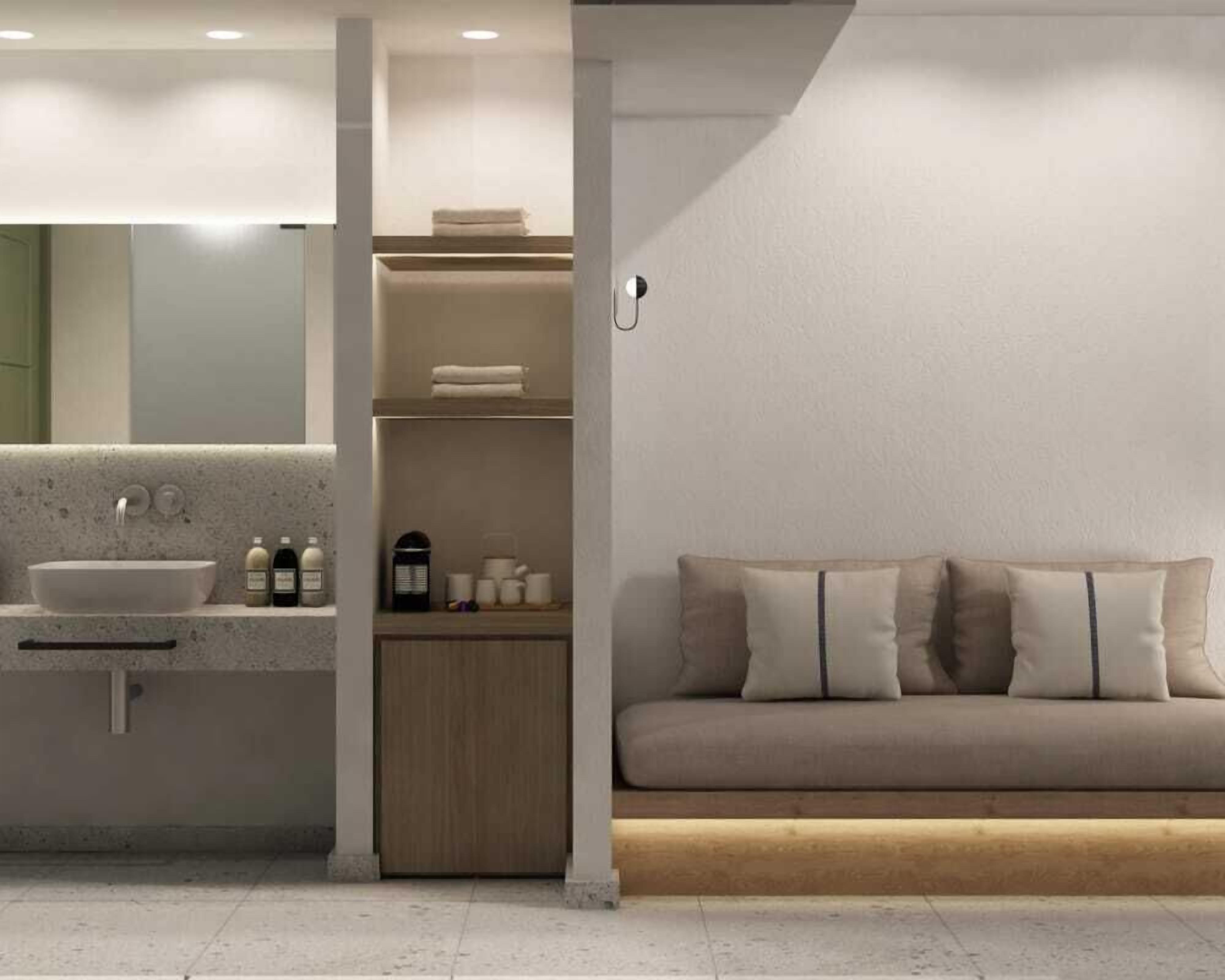 A modern bathroom with a sink, shelves, and a sofa.