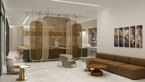 Un interior moderno con sofá, sillas, mesas y obras de arte en la pared.
