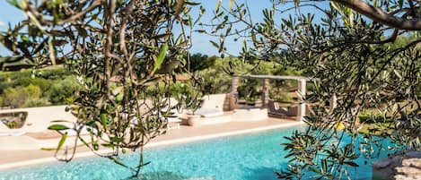 Una piscina al aire libre de temporada, sillones reclinables de piscina