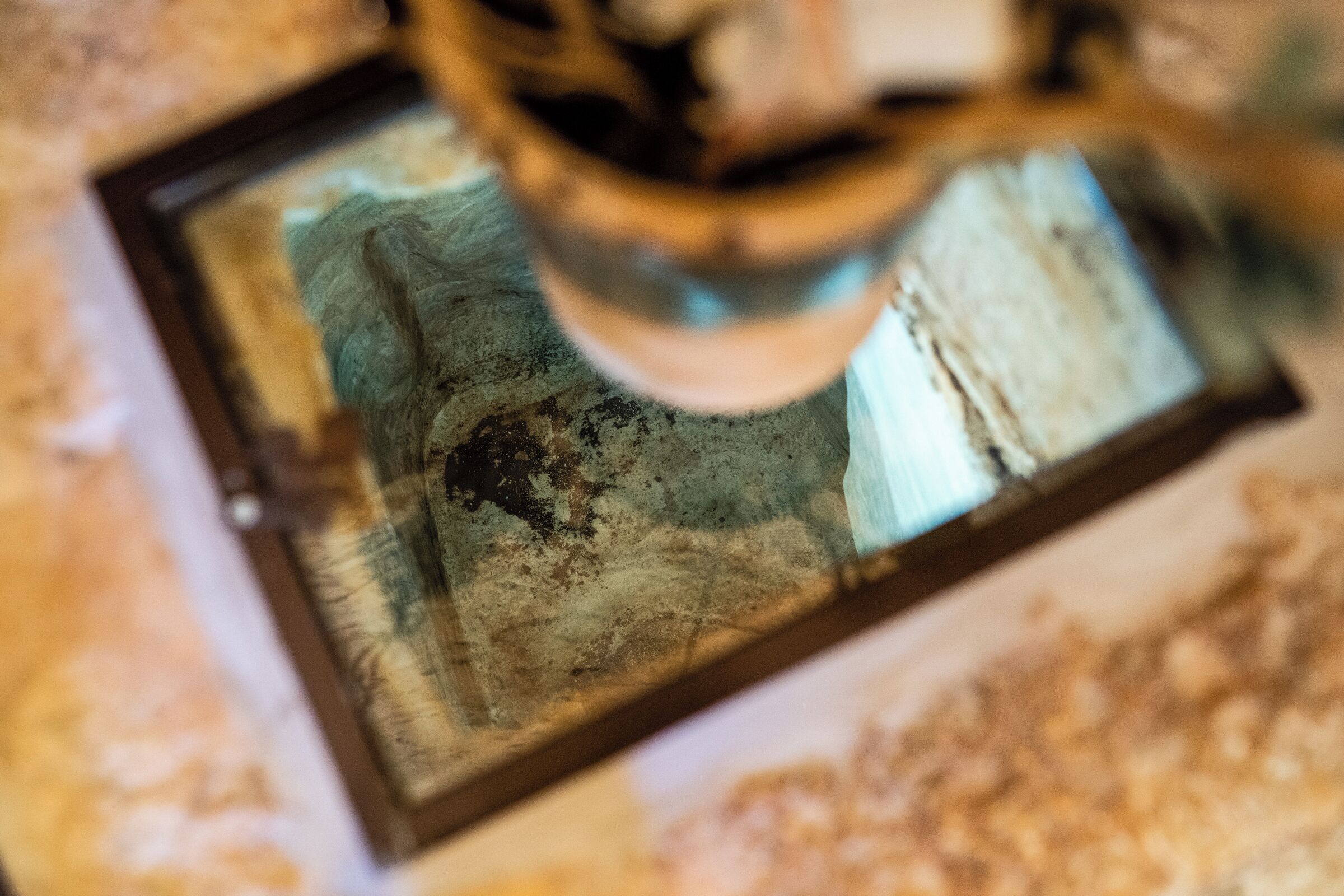 Et nærbillede af en detaljeret overflade med et reflekterende, muligvis metalagtigt objekt.