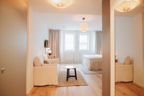 A modern hotel room with a sofa, a small table, and a bed. - The Lab Hotel (Solna)