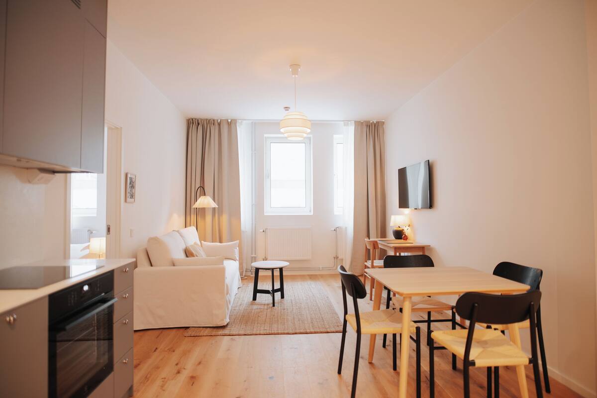 A modern apartment with a kitchen, dining area, and living room.