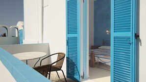 A room with a bed, a small table, and a chair.