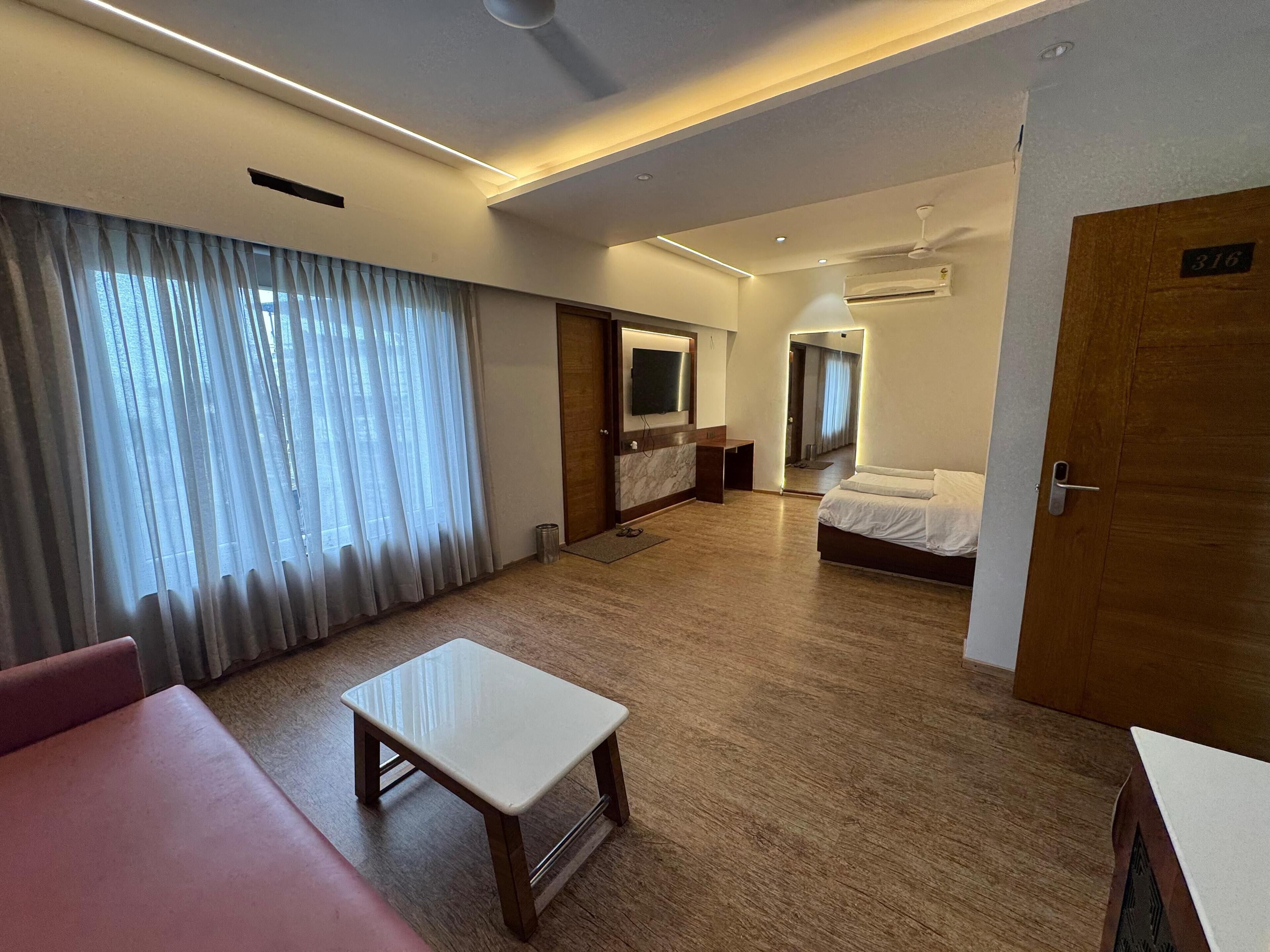 Une chambre d’hôtel comprenant un lit, un bureau, une chaise, une télévision et une salle de bain.