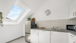A modern kitchen with white cabinets, a built-in oven, a microwave, and a large window with a view of the sky. - Vacation apartment Hirschegg, 2 x bath 5Z 10 beds kitchen 2 parking spaces, WLAN (Bad Friedrichshall)