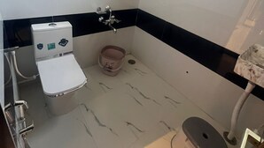 A small bathroom with a toilet, bidet, and sink. - Hotel Madhuban (Khuldabad)