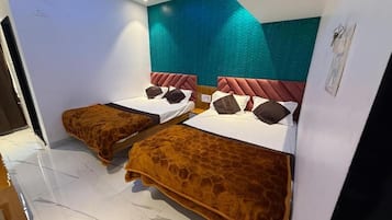 A hotel room with two beds, a teal accent wall, and a modern design.
