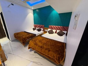 A hotel room with two beds, a teal accent wall, and a modern design. - Hotel Madhuban (Khuldabad)