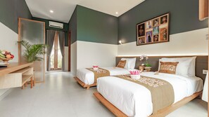 A hotel room with two beds, a desk, and a large window with curtains. - Juli House (Ubud)