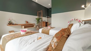 A hotel room with two beds, a wooden shelf with a potted plant, a mirror, and a hanging plant. - Juli House (Ubud)