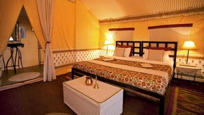 Une chambre confortable et bien éclairée, avec un grand lit, deux tables de chevet et un mur décoré d’un motif.