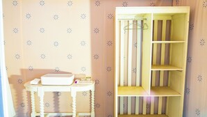 Une pièce avec une table blanche, un meuble blanc avec des étagères et un mur à motifs.