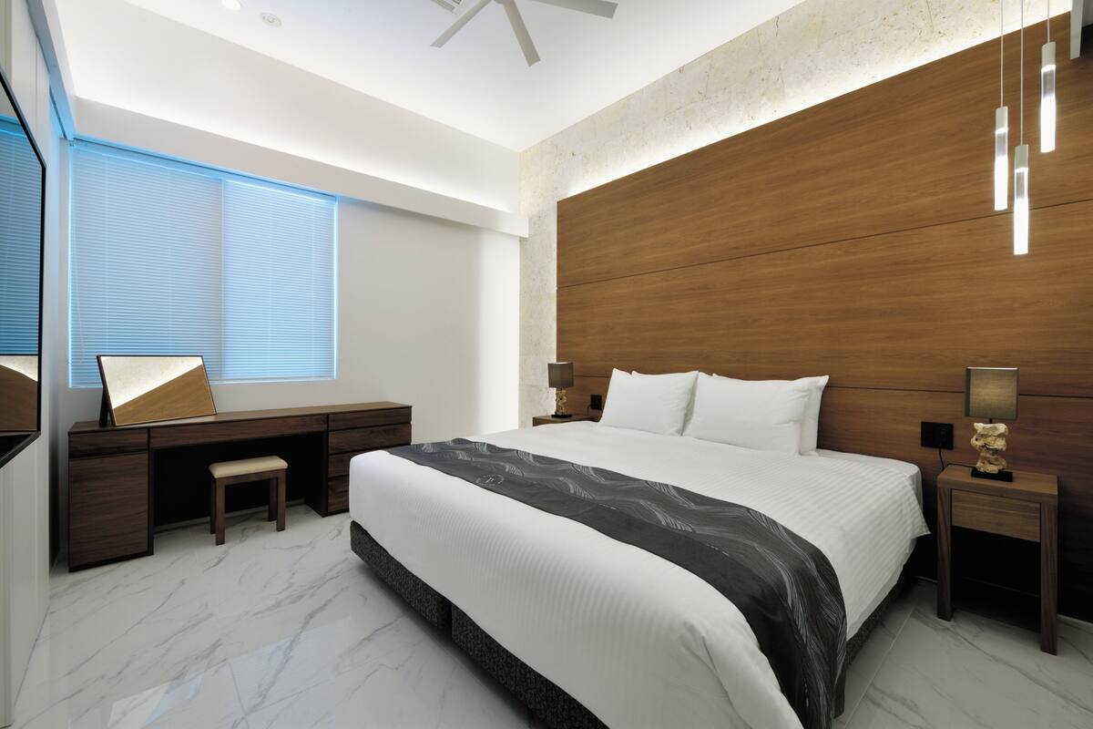 Un dormitorio moderno con una cama grande, un escritorio y una silla.
