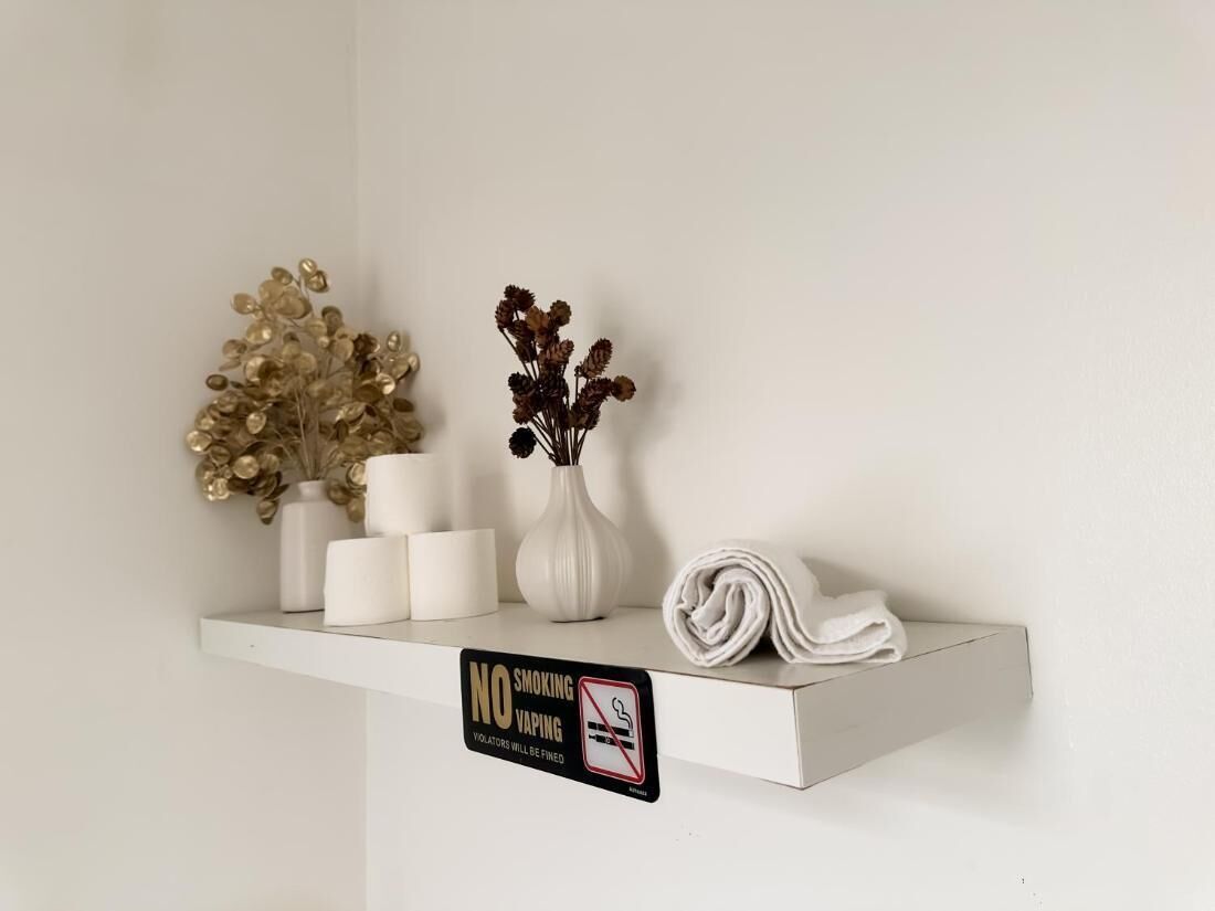 A white shelf with decorative items and a 'No Smoking' sign.