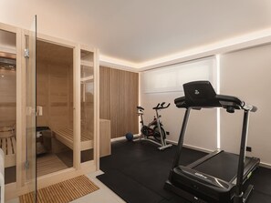 A modern home gym with a treadmill, stationary bike, and a sauna.