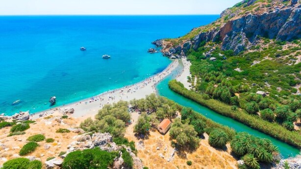 A coastal landscape with a beach, clear blue sea, and rocky terrain. - Casa Minervos | Unique Views (Souda)