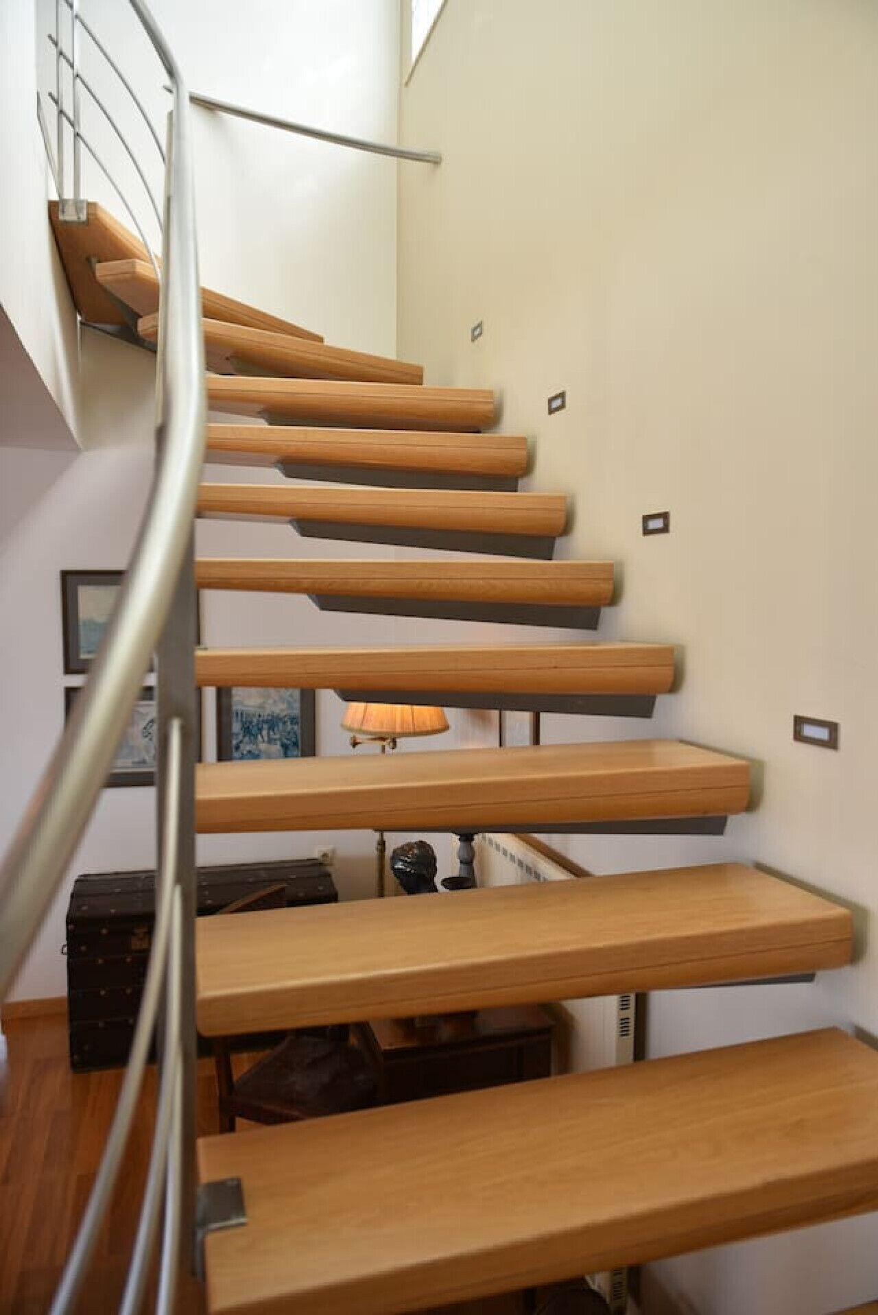A modern staircase with wooden steps and a metal railing.