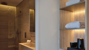 Une salle de bain moderne dotée d’une douche à parois de verre, de toilettes intégrées et d’un meuble-lavabo avec un miroir.