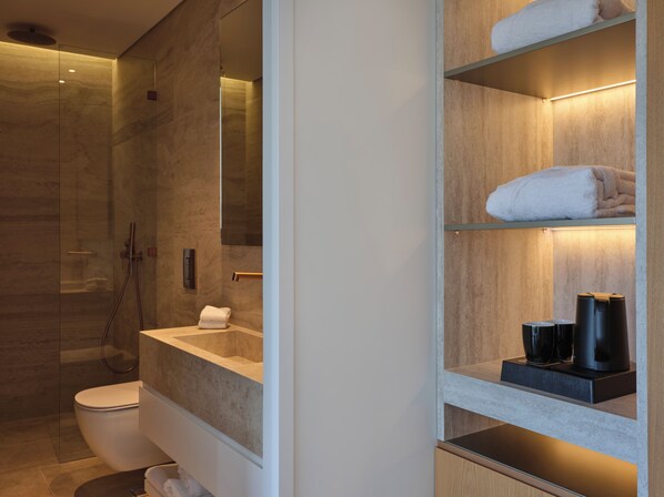 A modern bathroom with a glass shower enclosure, a built-in toilet, and a vanity with a mirror. - Nur Riviera Living (Palaio Faliro)