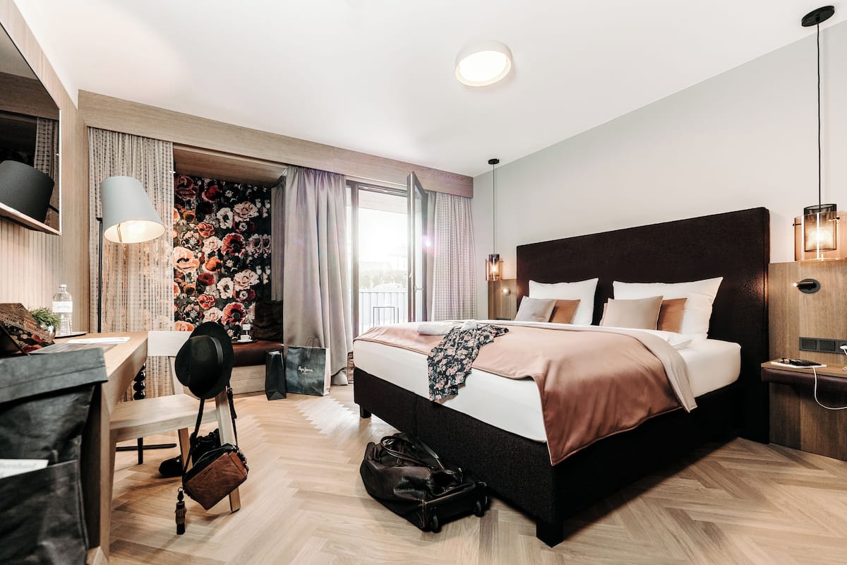 Una habitación de hotel moderna con una cama grande, un escritorio y una silla.