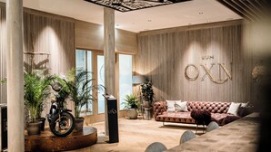 A modern interior with a wooden floor, a leather sofa, and a motorcycle.