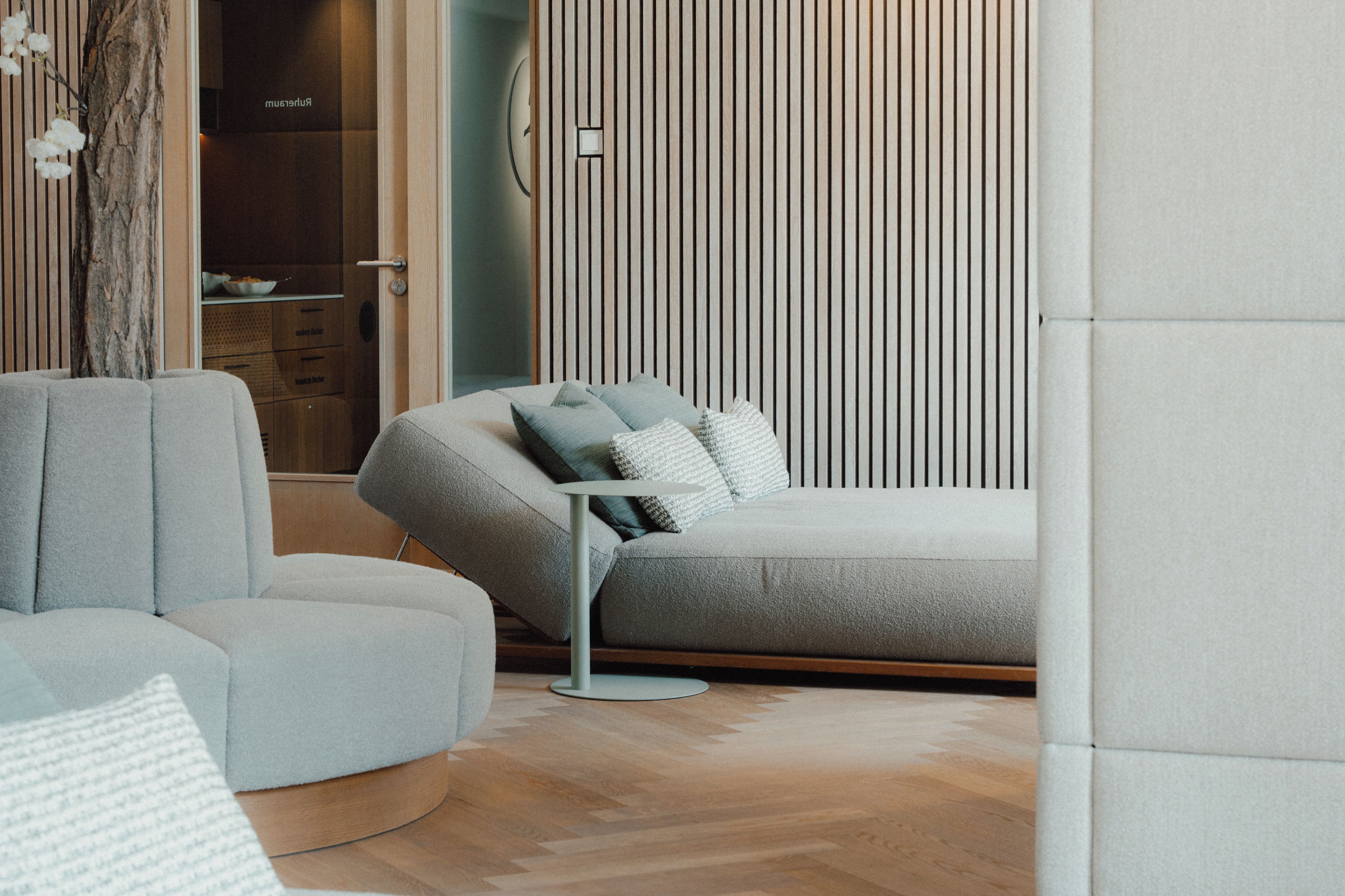 A modern living room with a sectional sofa, a round coffee table, and a minimalist decor style.