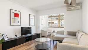 A modern living room with a flat-screen TV, a round coffee table, and a sofa. - Vistas SAGRADA FAMILIA piso grande y luminoso (Barcelona)