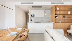A modern kitchen with white cabinets, a central island, and pendant lighting.