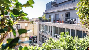 Un edificio moderno con varios balcones, ventanas amplias y unidades de aire acondicionado.