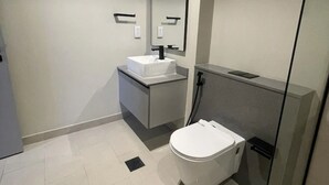 A modern bathroom with a toilet, sink, and mirror.
