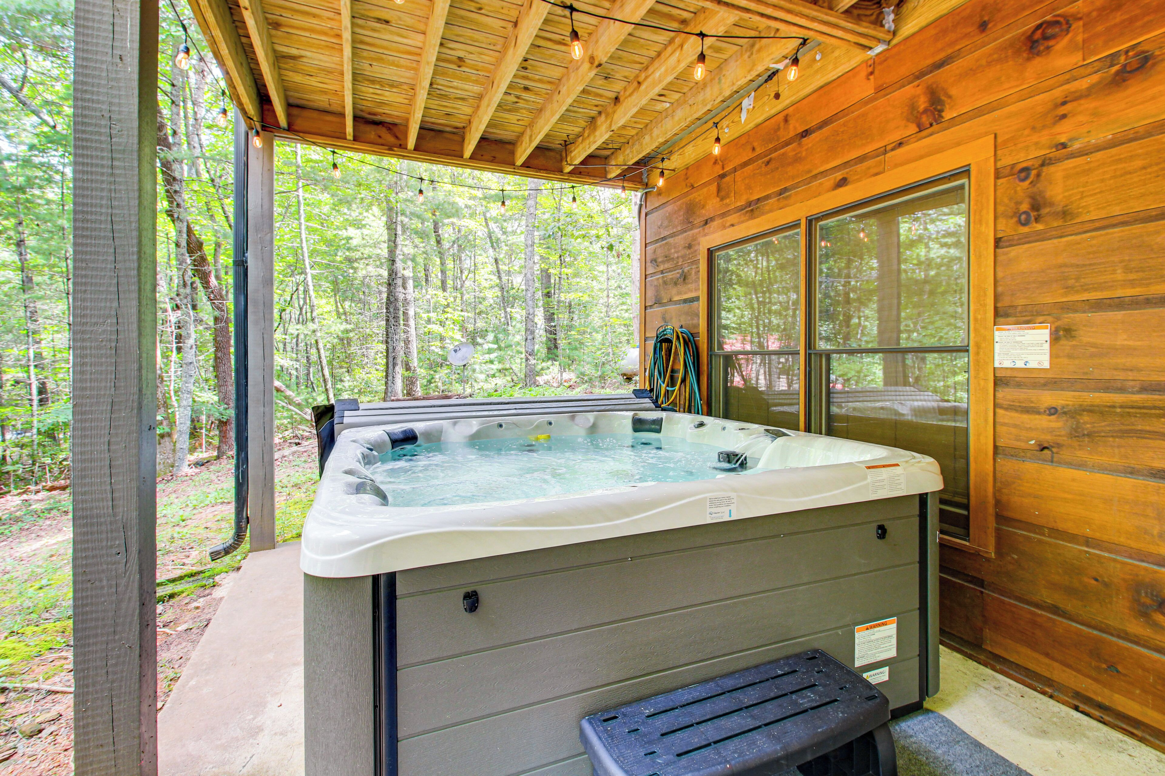 Un bain à remous dans un chalet en bois avec vue sur la forêt.