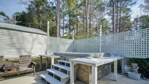 An outdoor patio area with a wooden bench, a table, and a white fence. - Pet-friendly Home w/ Private Hot Tub in Wilmington (Wilmington)