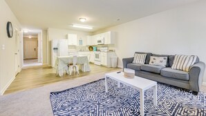 A modern living room with a grey sofa, a white coffee table, and a patterned rug. - 9 Mi to Shore: Family-friendly Sunset Beach Home (Sunset Beach)