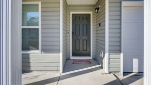 A house entrance with a gray door, a welcome mat, and a window to the left. - 9 Mi to Shore: Family-friendly Sunset Beach Home (Sunset Beach)