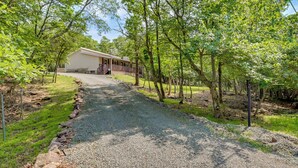 A gravel path leading to a building with a porch, surrounded by trees. - Community Pools & Hot Tub: Albrightsville Cottage! (Albrightsville)