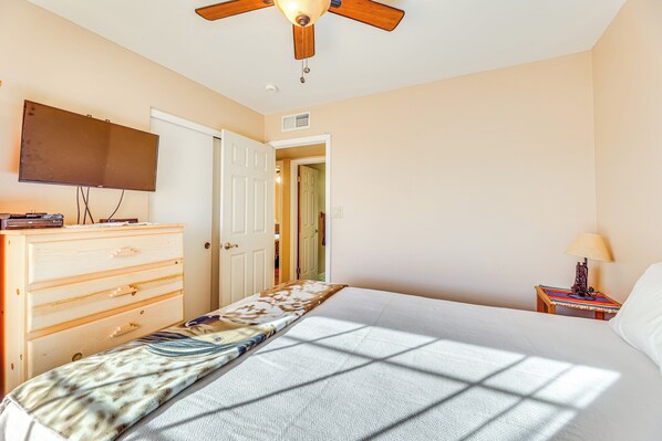 A bedroom with a bed, a dresser, a television, a ceiling fan, and a nightstand with a lamp. - Near Golfing & Green Spaces: Florence Family Home! (Florence)