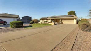 Une allée menant à une maison, avec des panneaux solaires installés sur le toit.
