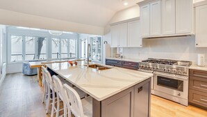 A spacious kitchen with a large island, stainless steel appliances, and ample natural light from large windows. - Lake Wisconsin Retreat w/ Dock: Great for Groups! (Lodi)