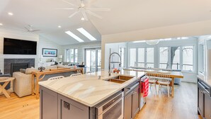 A spacious kitchen with a central island, wooden flooring, and a large window providing natural light. - Lake Wisconsin Retreat w/ Dock: Great for Groups! (Lodi)