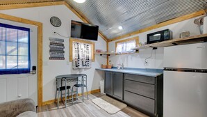 Una cocina compacta con comedor, microondas y refrigerador.
