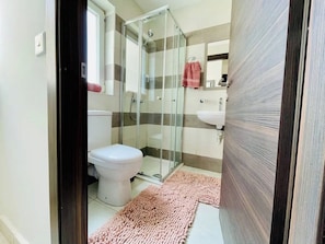 Un baño con inodoro, ducha y lavamanos.