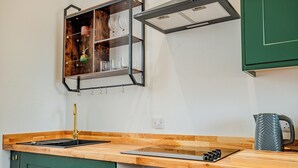 A kitchen with a wooden countertop, a built-in oven, and a green cabinet. - WhiskAwayStays No. 58 Studio No. 6 (Worcester)