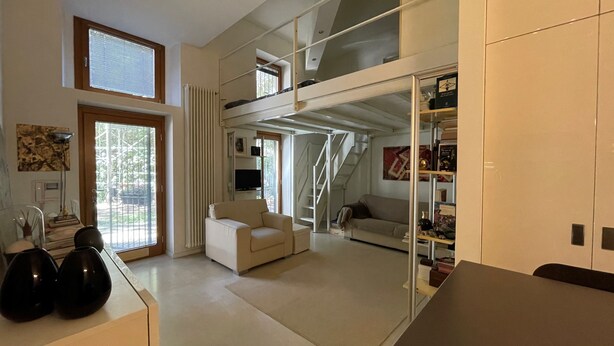 A modern living space with a sofa, a coffee table, a TV, and a bookshelf.