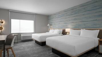 A hotel room with two beds, a desk, a chair, and a large window.