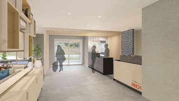 A reception area with a reception desk, a seating area with a sofa and a coffee table, and a large window providing a view of the outdoors.