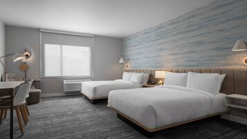 A hotel room with two beds, a desk, a chair, a window, and a wall with a textured design.