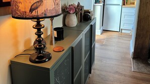 Ett kök med modern design, med en bänkskiva i trä, en inbyggd spis och ett kylskåp.