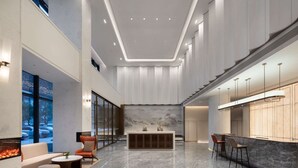 A spacious lobby with a marble floor, a reception desk, seating area, and large windows offering a view of the outside. - Days Inn by Wyndham Hangzhou Gongshu (Hangzhou)