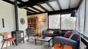 A cozy living room with a fireplace, a sofa, a coffee table, and a lamp. - Bungalow for 4 People in Wildrijk (Sint Maartensvlotbrug)